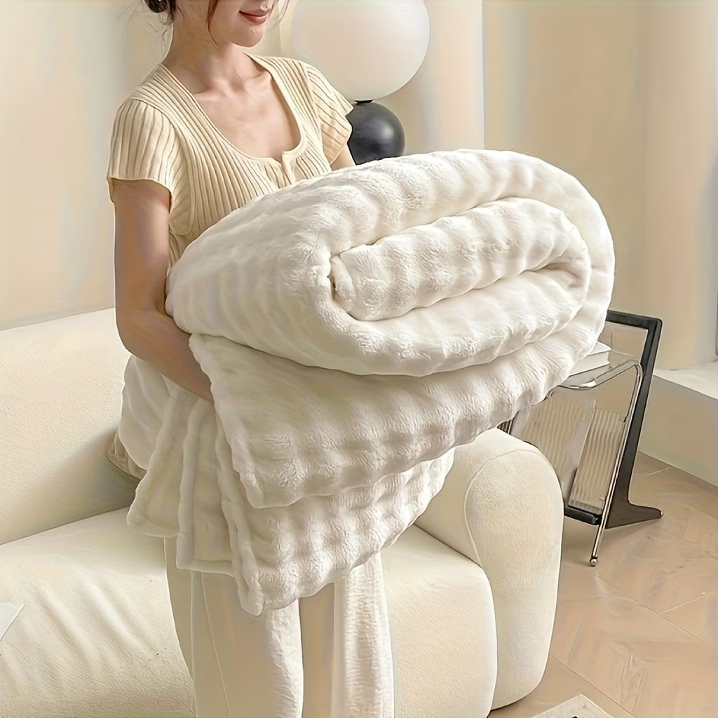 Person holding a large white blanket in a cozy living room.