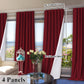 Red curtains with measurements and a vase of flowers on a table.