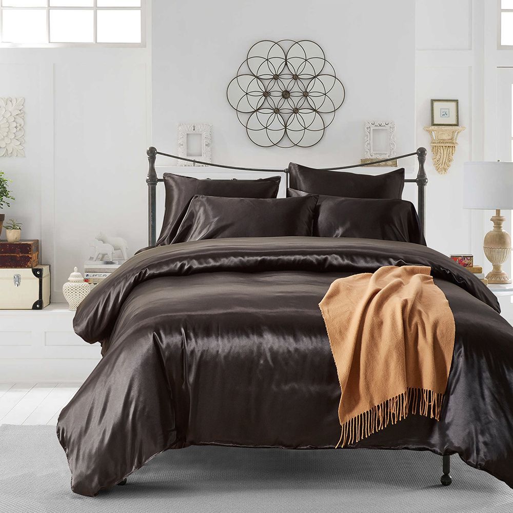 Brown satin comforter set on a bed in a stylish bedroom with decorative elements.