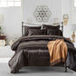 Brown satin comforter set on a bed in a stylish bedroom with decorative elements.