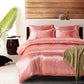 Pink bedding set on a bed with decorative elements in the background
