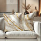 Decorative pillows with gold accents on a white sofa in a stylish room.