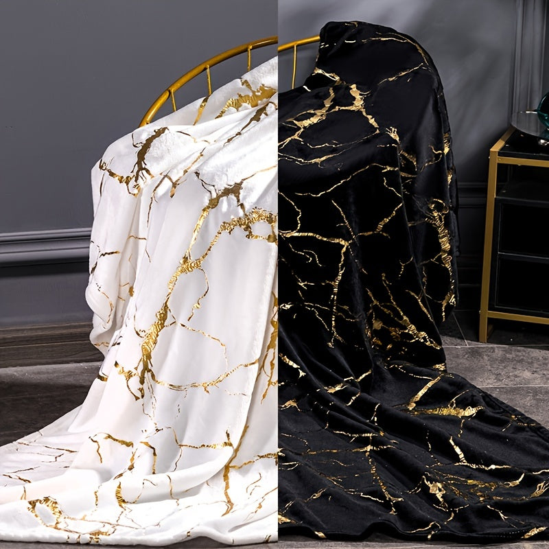 Two fabric samples with gold marble pattern, one white and one black, draped over chairs.