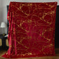 Red fabric with gold patterns draped over a chair in a room setting.