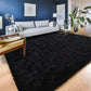 Living room with a black rug, gray sofa, and wooden floor.