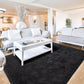 Modern living room with white sofas, a coffee table, and decorative elements.