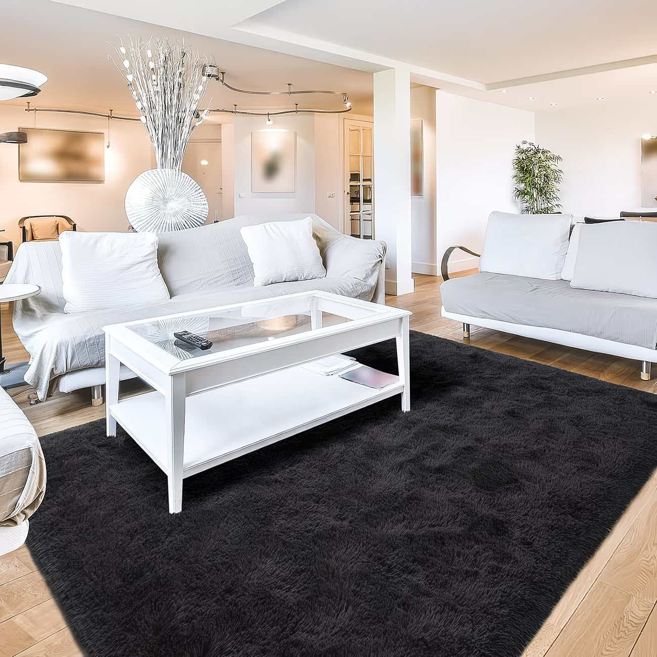 Modern living room with white sofas, a coffee table, and decorative elements.
