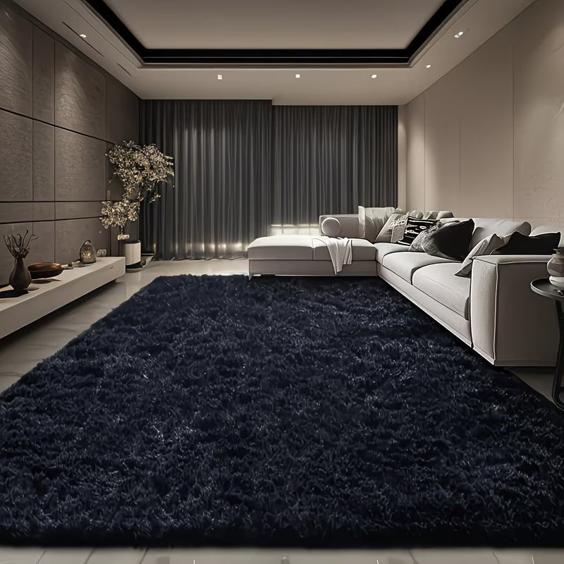 Modern living room with a dark blue rug, gray sofa, and decorative elements.