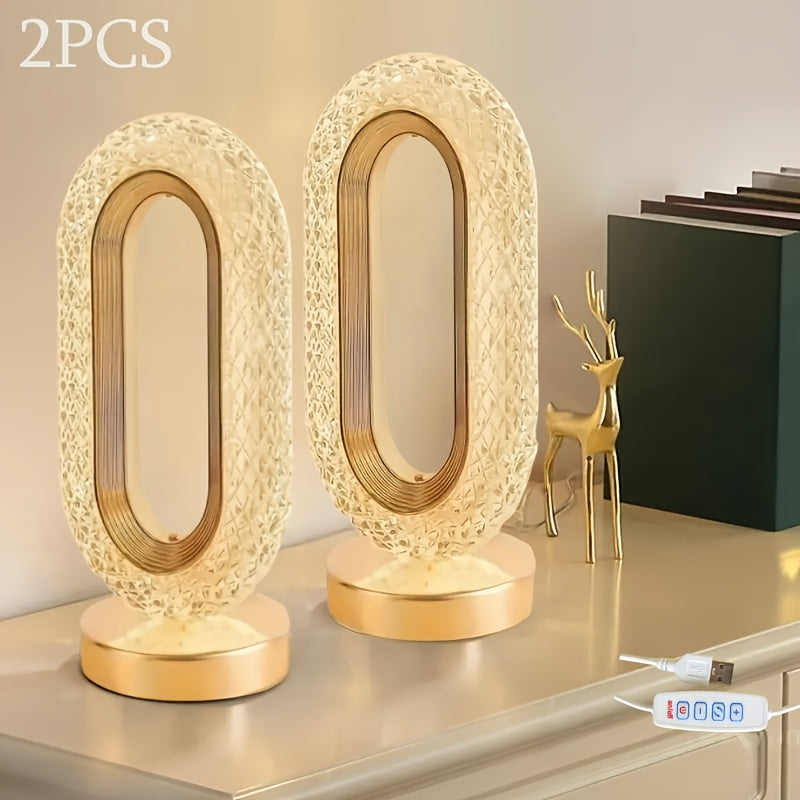 Two gold table lamps on a surface with a thermometer in the background.