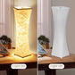 Two lamps side by side, one lit and one off, on a desk with a laptop and notebook.