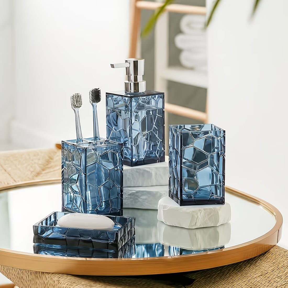 Bathroom accessories set with blue geometric design on a round mirror table.