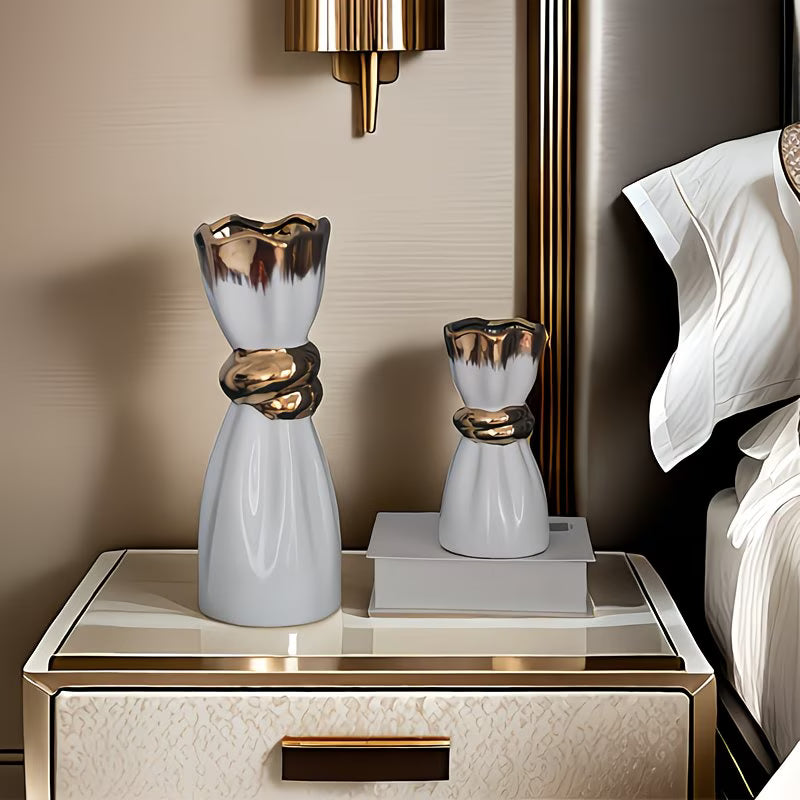Decorative vases on a nightstand with a bed in the background