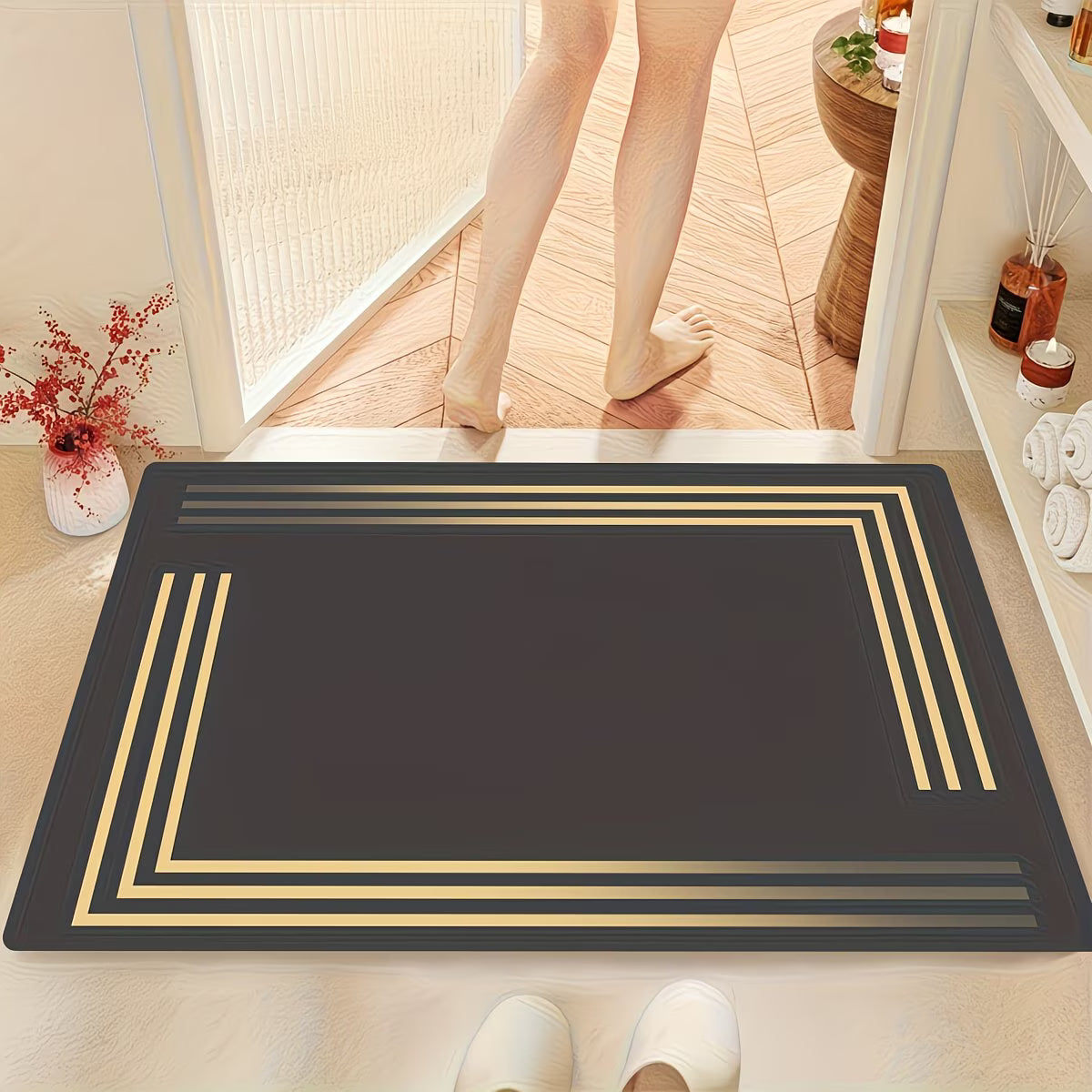 Black doormat with gold border on a wooden floor, person entering through glass door.