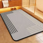 Gray bath mat with geometric patterns on a wooden floor