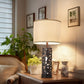 Decorative table lamp on a wooden surface with a cozy indoor setting.
