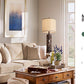 Living room with beige sectional sofa, wooden coffee table, and decorative elements.