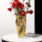 Decorative glass vase with red flowers on a white surface