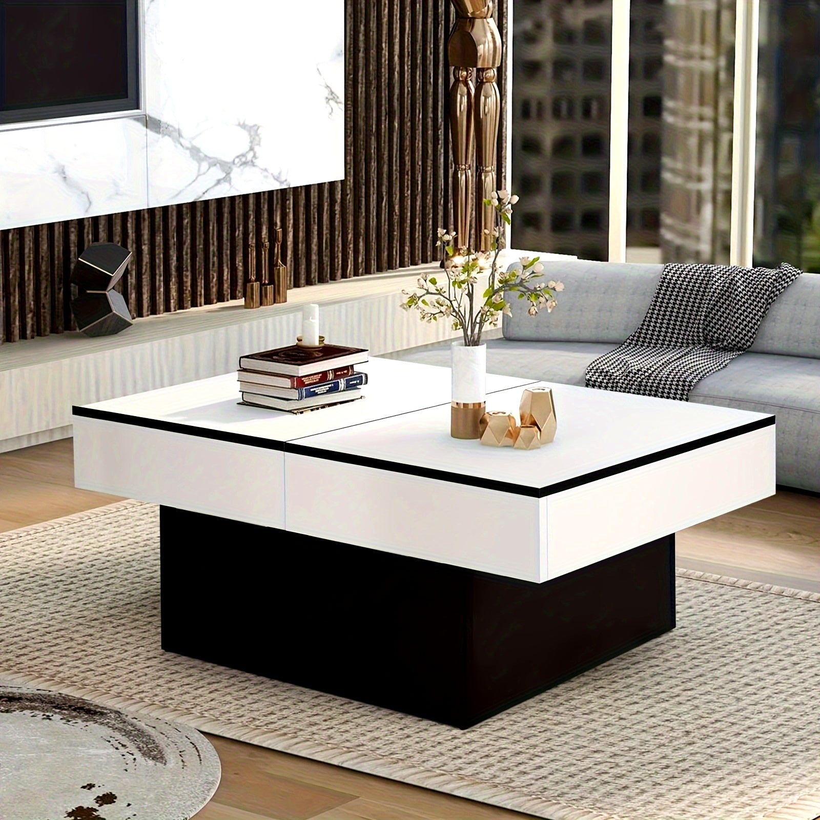 Modern living room with a white and black coffee table, books, and decorative items.
