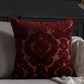 Decorative red pillow with intricate patterns on a gray sofa.