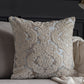 Decorative pillow with intricate lace pattern on a couch.
