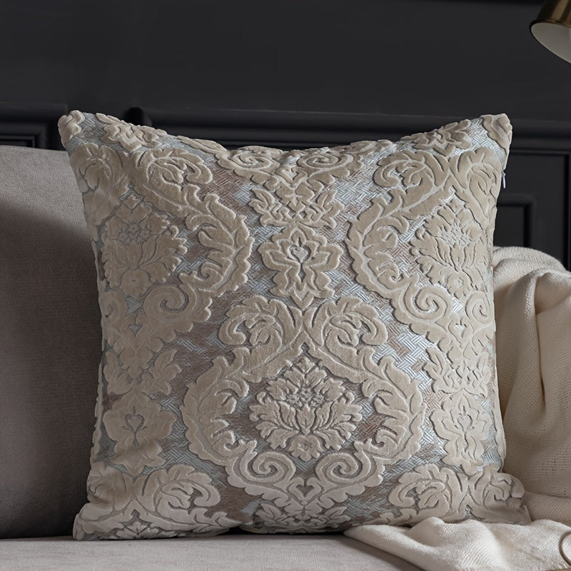 Decorative pillow with intricate lace pattern on a couch.