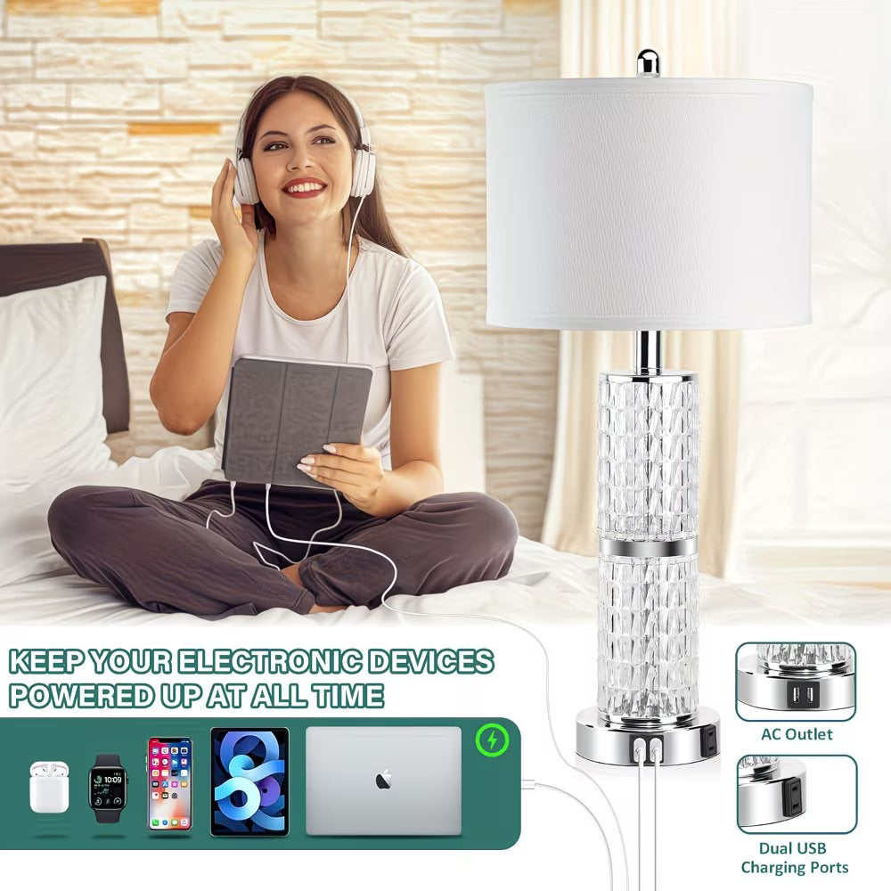 Woman sitting on a bed with headphones, using a tablet, next to a modern lamp with charging ports.