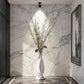 Decorative vase with dried plants against a marble wall