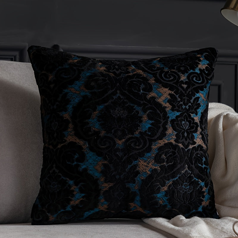 Decorative pillow with black and blue floral pattern on a gray sofa.