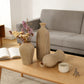 Decorative vases and a cup on a coffee table in a living room setting.