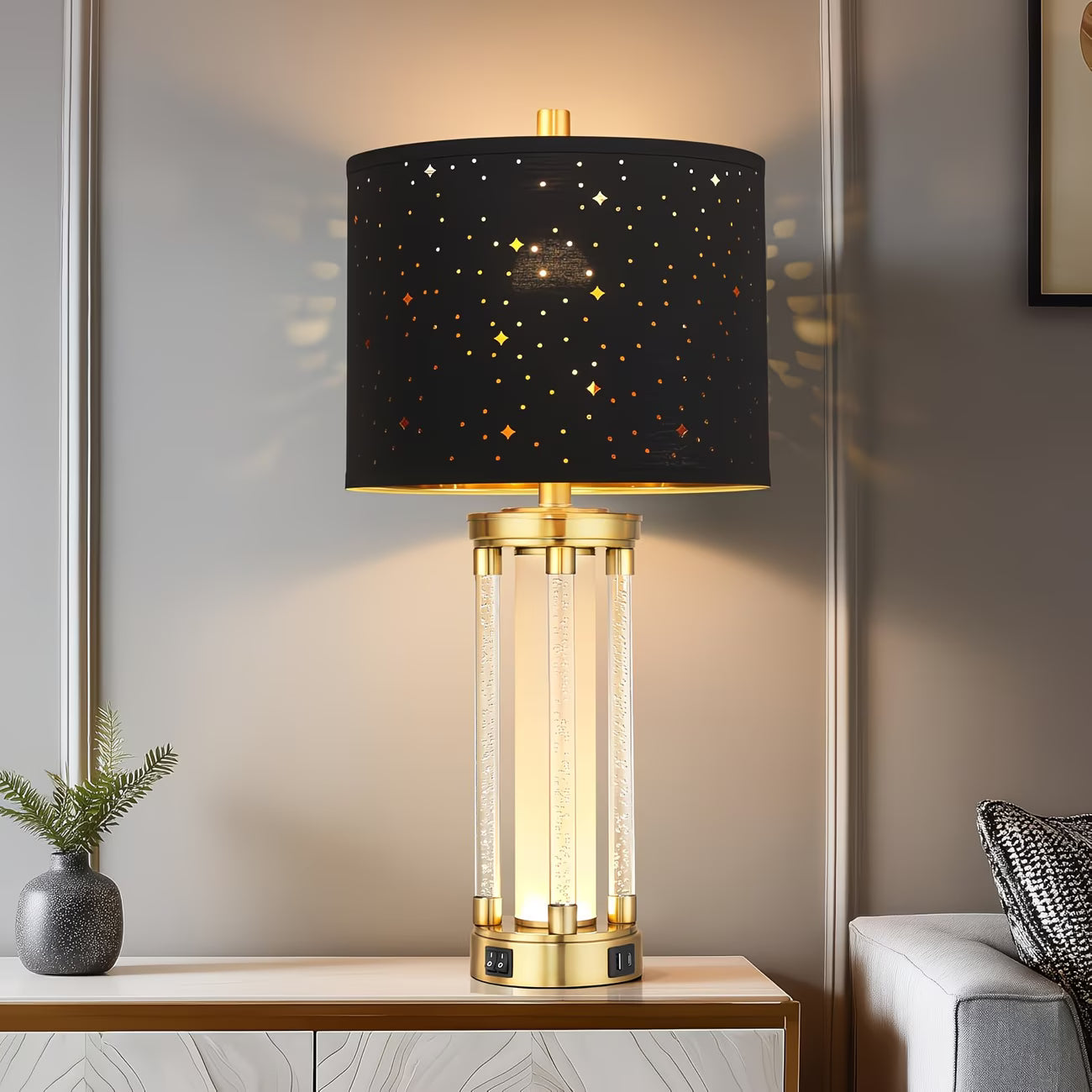 Decorative table lamp with black shade and gold base on a wooden table.