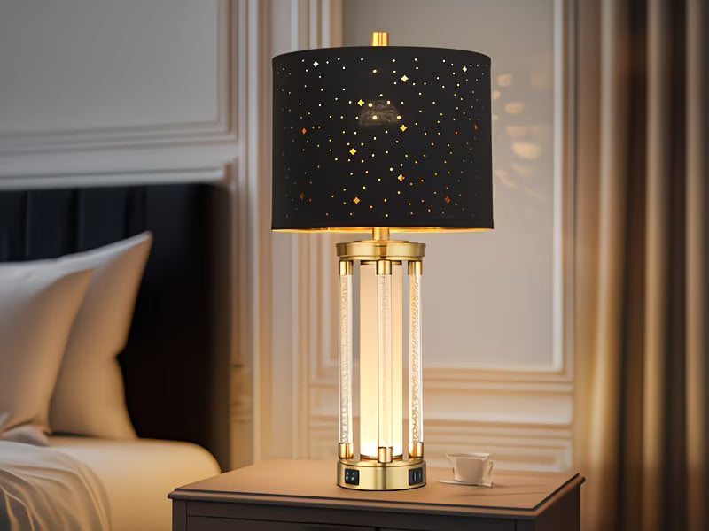 Decorative table lamp with black star-patterned shade on a wooden nightstand.