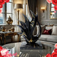 Decorative black and gold sculpture on a table with roses and 'Love' text in a stylish room.