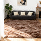 Living room with a dark gray sofa, fluffy brown rug, and abstract art on the wall.