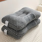 Gray U-shaped pillow with honeycomb pattern on a light surface
