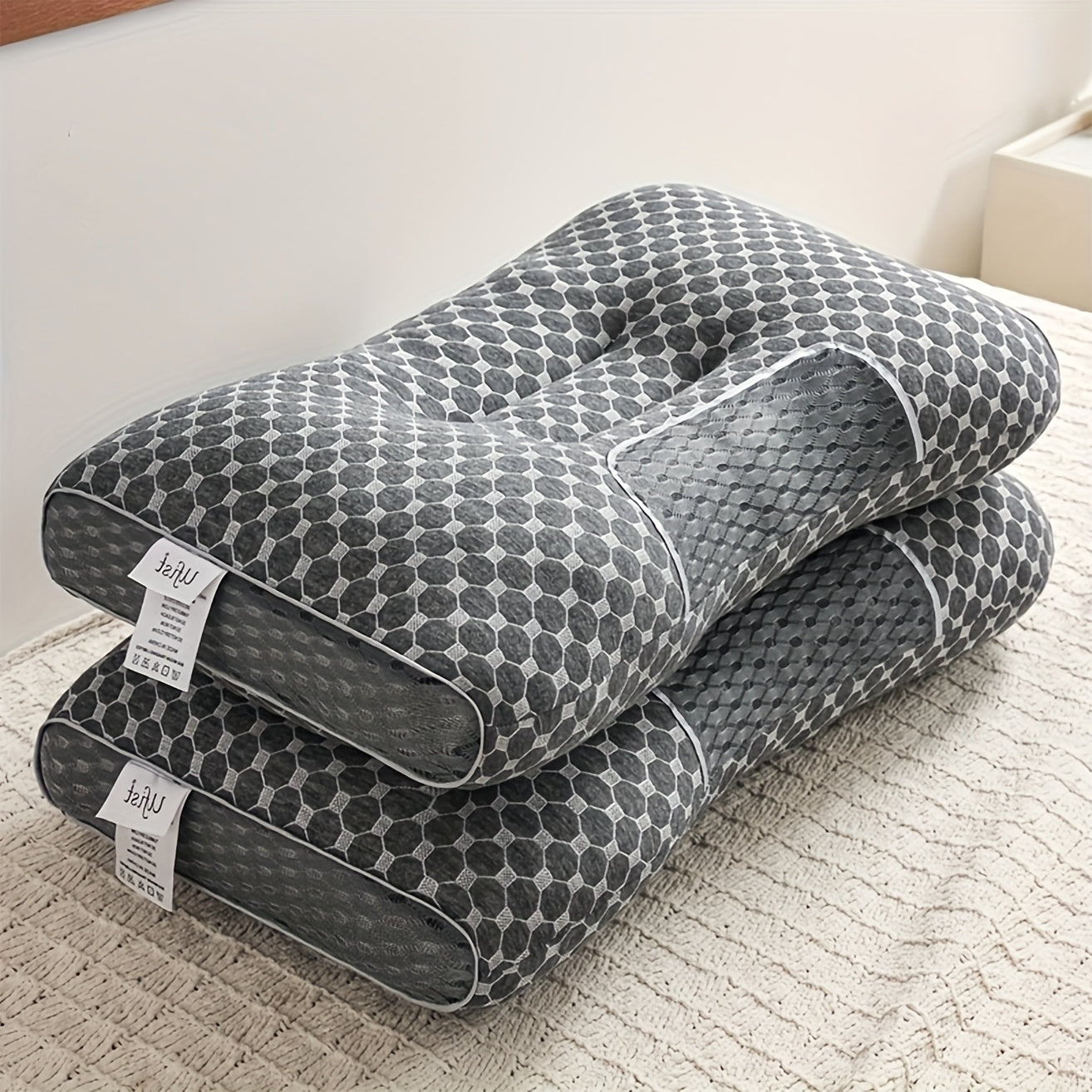 Gray U-shaped pillow with honeycomb pattern on a light surface