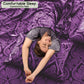 Person lying on a purple patterned bedspread with 'Comfortable Sleep' text at the top.