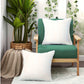Green chair with white cushions and a plant in a room.