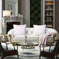 Luxurious living room with white sofa, decorative pillows, and a fireplace.