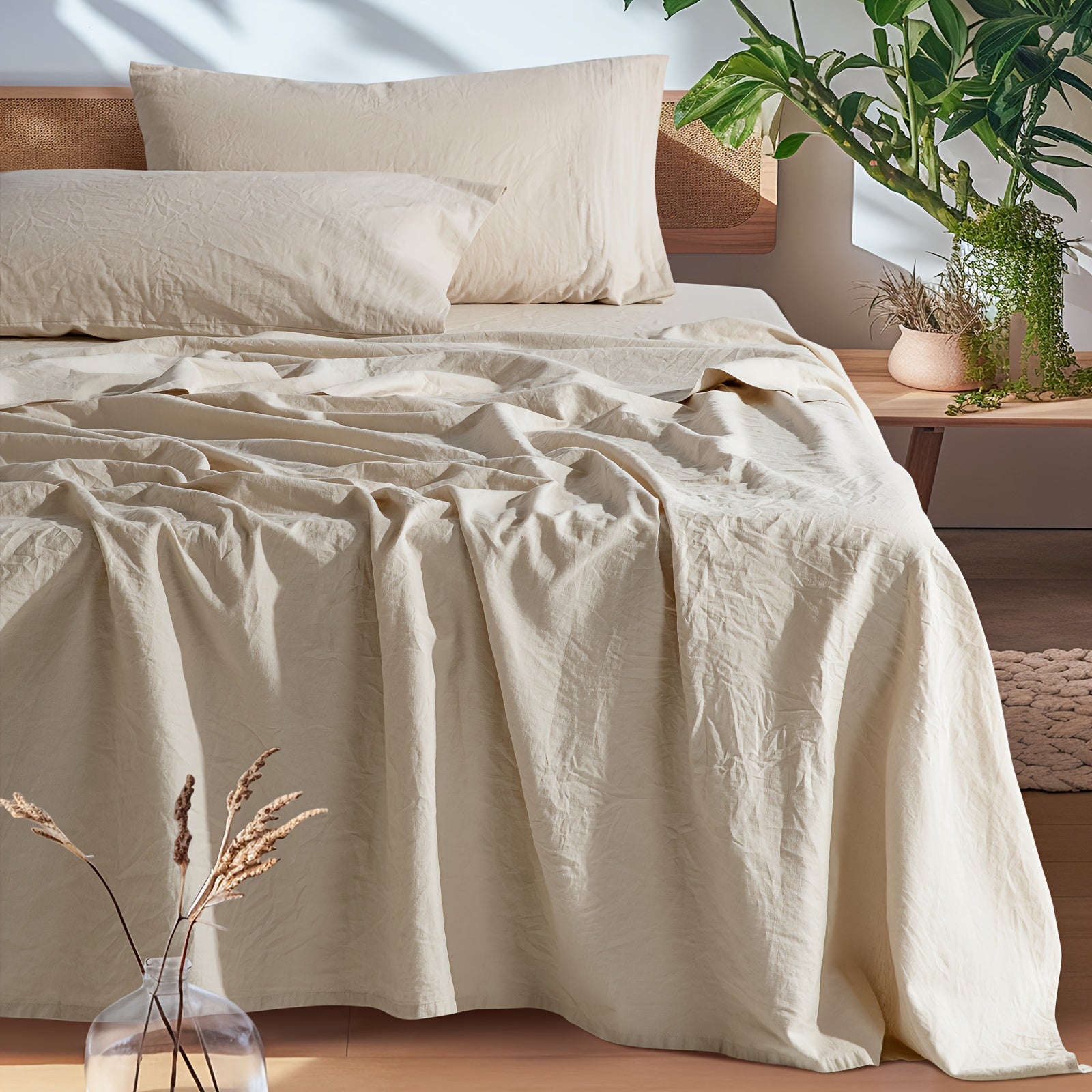 Beige bedding on a bed with a wooden headboard and plants in the background