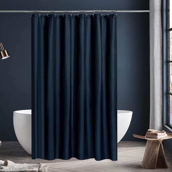Navy blue shower curtain in a bathroom with a white bathtub and wooden stool.