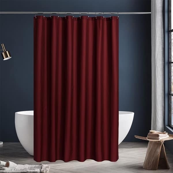 Red shower curtain in a bathroom with a white bathtub and dark blue walls.