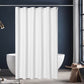 White shower curtain in a modern bathroom with a dark wall and wooden stool.