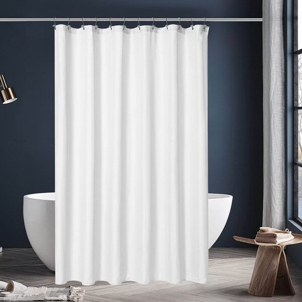 White shower curtain in a modern bathroom with a dark wall and wooden stool.