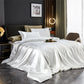 White satin bedding set on a bed in a stylish bedroom.