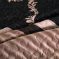 Close-up of quilted fabric with floral embroidery in black, beige, and brown.