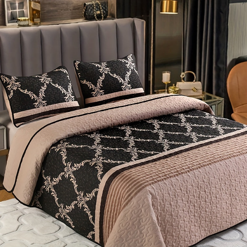 Bed with black and white patterned quilt and pillows in a bedroom setting.