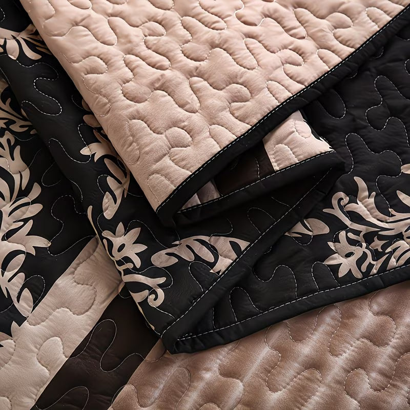 Close-up of quilted fabric with black and beige patterns