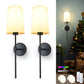 Two wall-mounted lamps with a Christmas tree and presents in the background.