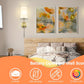 Bedroom setting with wall sconces, floral artwork, and a bed with a wooden headboard.
