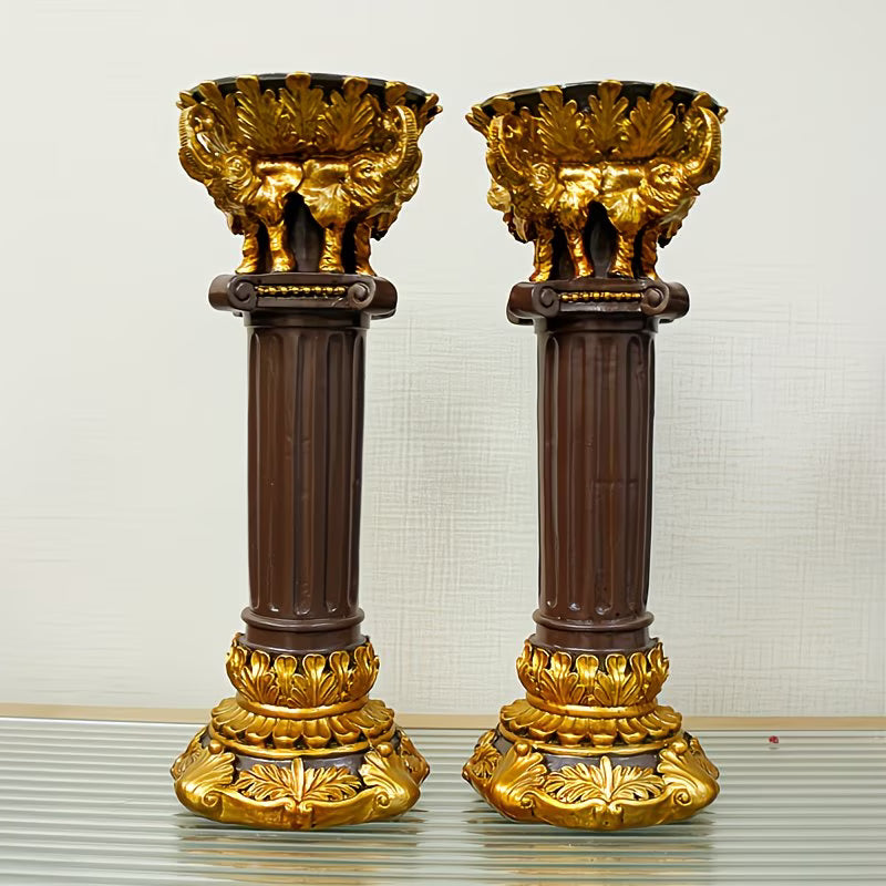 Two ornate candle holders with gold and brown detailing on a neutral background